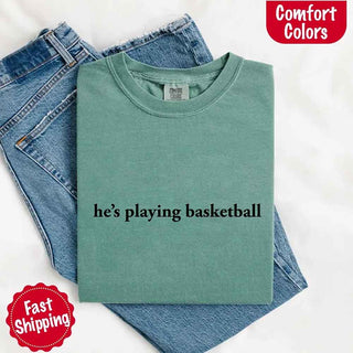 He’s Playing Basketball – Funny Sports Girlfriend Comfort Color Shirt for Women - A Roese Boutique