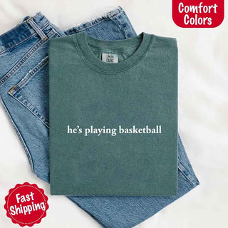 He’s Playing Basketball – Funny Sports Girlfriend Comfort Color Shirt for Women - A Roese Boutique